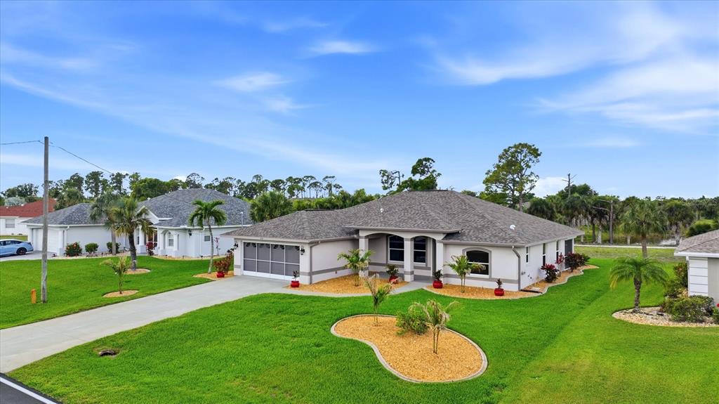 An exterior view of a single-story house with a gray roof and a concrete driveway — 828 ROTONDA CIRCLE, ROTONDA WEST, FL