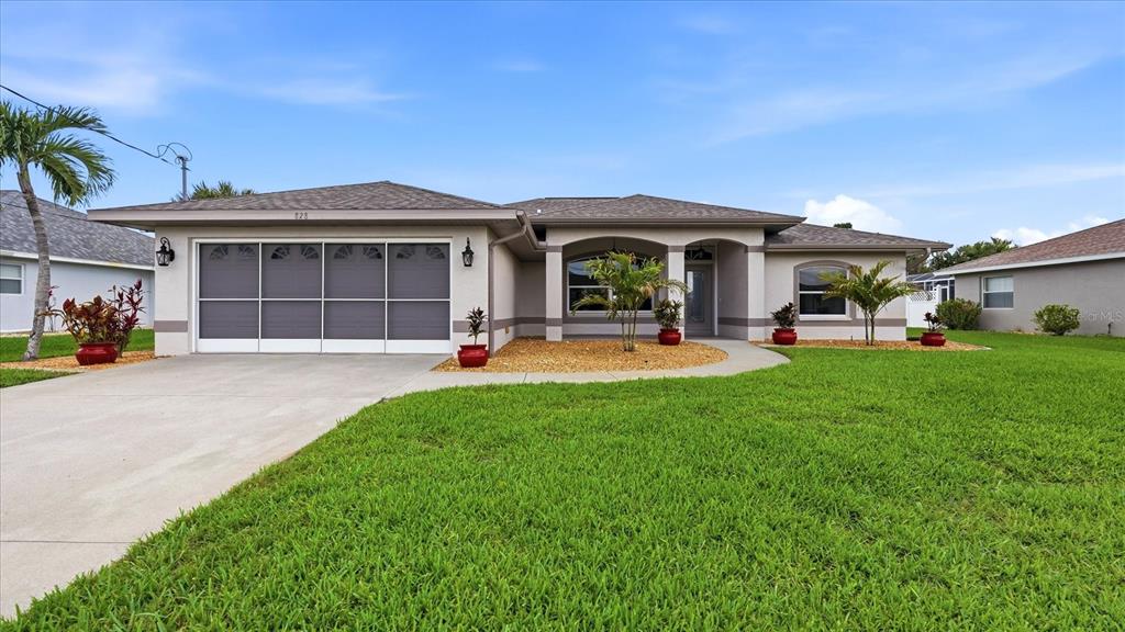 A single-story house with a garage, a covered entryway, and a green lawn — 828 ROTONDA CIRCLE, ROTONDA WEST, FL