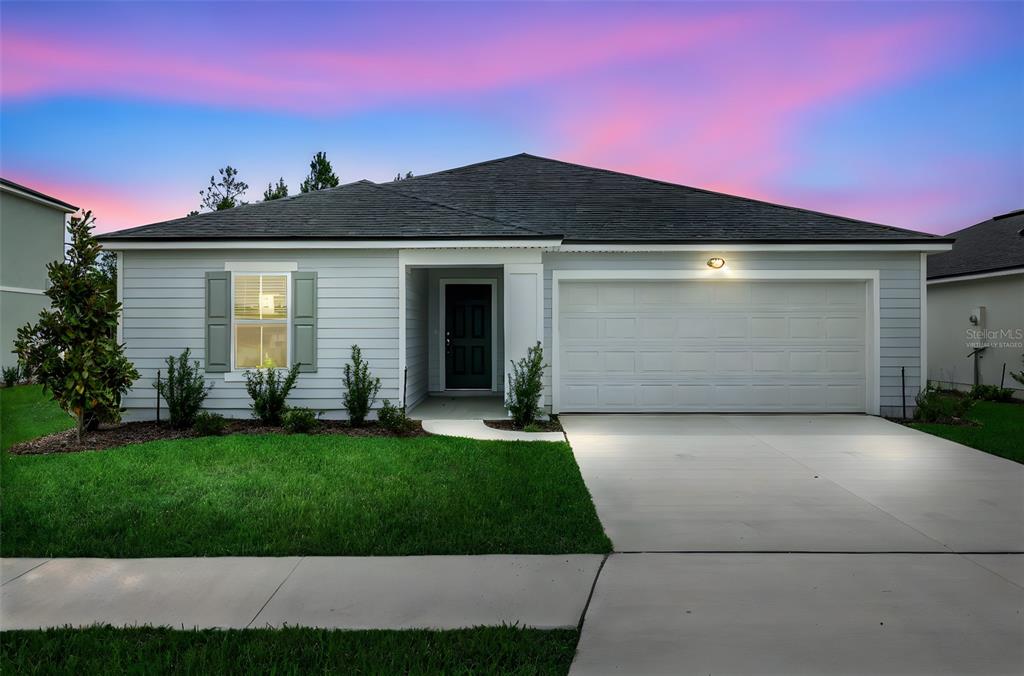 A single-story house with light gray siding, a two-car garage, and a front lawn — 3829 HOLSTEIN WAY, GREEN COVE SPRINGS, FL