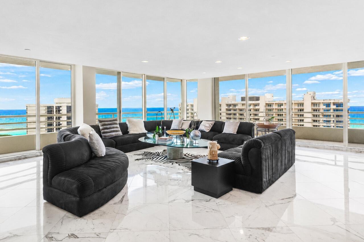 A living room with black sectional sofas, a glass coffee table, and floor-to-ceiling ocean views — 4201 N Ocean Boulevard # 1801, Boca Raton FL 33431, BOCA RATON, FL