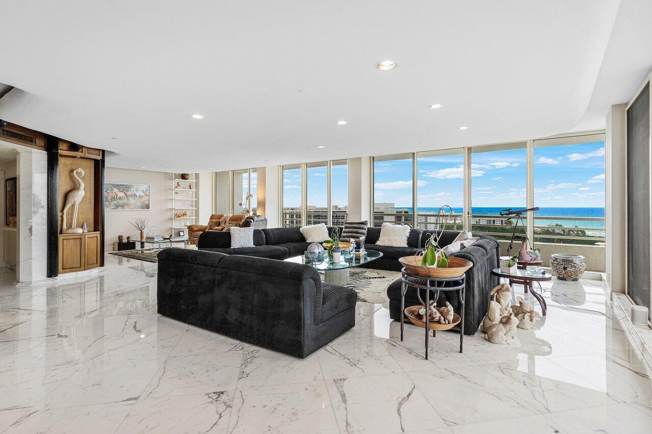 A spacious living room features white marble floors, a large dark sectional, and floor-to-ceiling windows — 4201 N Ocean Boulevard # 1801, Boca Raton FL 33431, BOCA RATON, FL