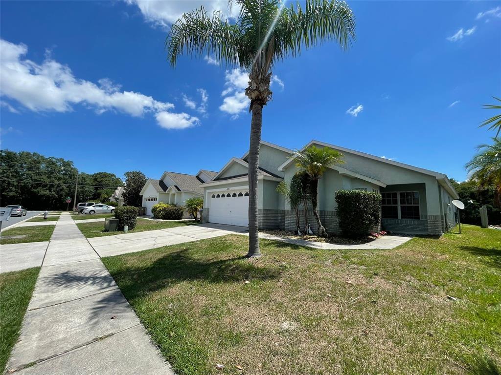 A single-story suburban house with a two-car garage, a palm tree, and a concrete driveway — 4718 PRAIRIE POINT BOULEVARD, KISSIMMEE, FL