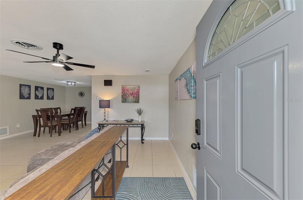 An entryway opens into a living and dining area with tile flooring and a ceiling fan — 361 FALKLAND ROAD, VENICE, FL