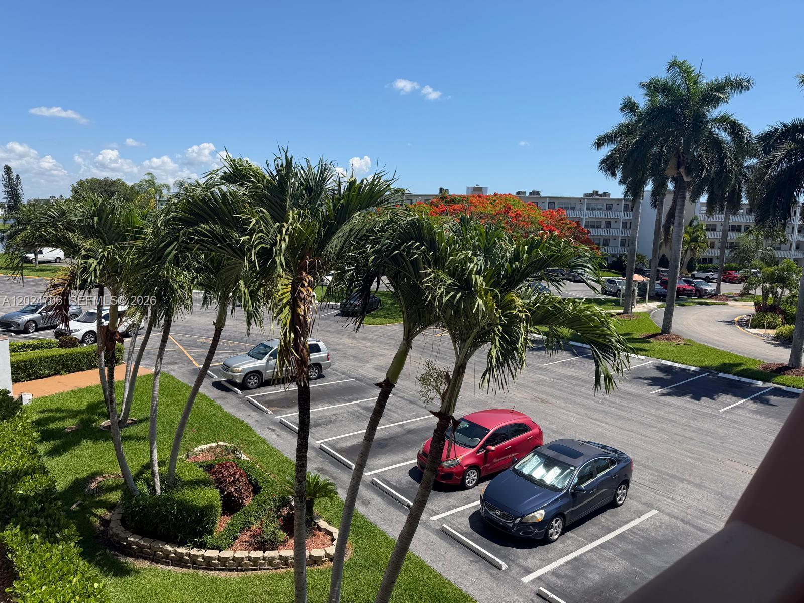 An elevated view of a parking lot with palm trees and several parked cars — 3069 Cornwall D # 3069, Boca Raton FL 33434, BOCA RATON, FL