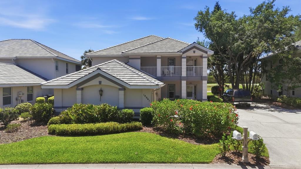 A two-story residential building with a tiled roof, white stucco exterior, and a front lawn — 14061 WILLOW GLEN COURT UNIT 239, PORT CHARLOTTE, FL