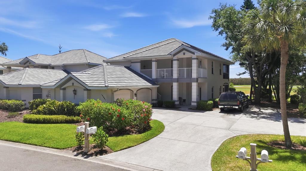 A two-story house with a tiled roof, a concrete driveway, and a two-car garage — 14061 WILLOW GLEN COURT UNIT 239, PORT CHARLOTTE, FL