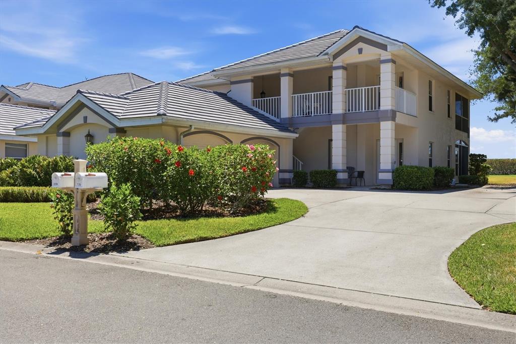 A two-story house with a concrete driveway, a tiled roof, and a second-floor balcony — 14061 WILLOW GLEN COURT UNIT 239, PORT CHARLOTTE, FL