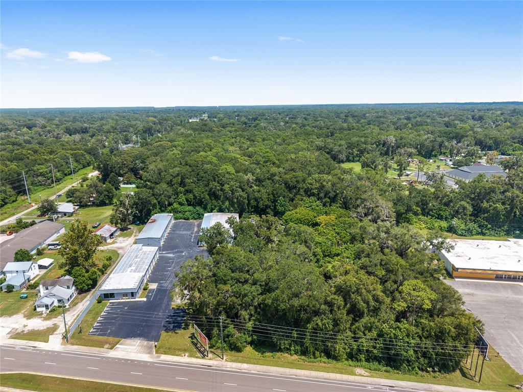 An aerial view shows a commercial storage facility next to a wooded lot and road — 3007 NE JACKSONVILLE ROAD, OCALA, FL