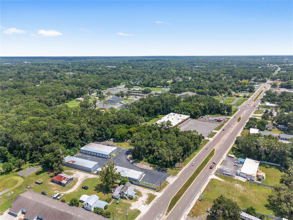 An aerial view shows a commercial property with several buildings and parking lots near a road — 3007 NE JACKSONVILLE ROAD, OCALA, FL