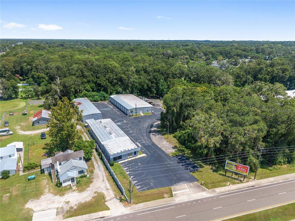 An aerial view shows a commercial property with three metal buildings and a paved parking lot — 3007 NE JACKSONVILLE ROAD, OCALA, FL