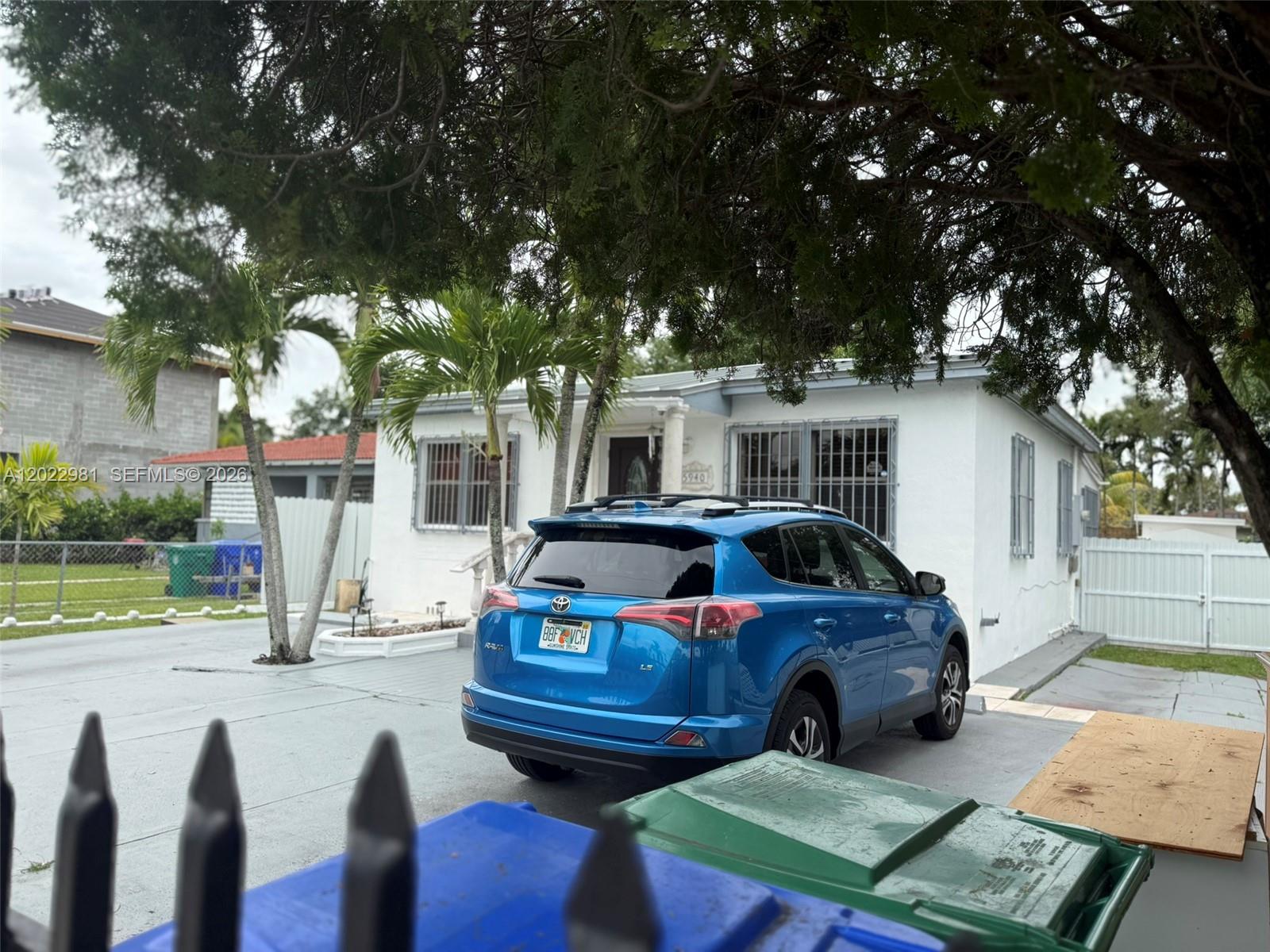 A blue SUV is parked in the driveway of a white single-story house — 5940 SW 2nd St, Miami FL 33144, MIAMI, FL