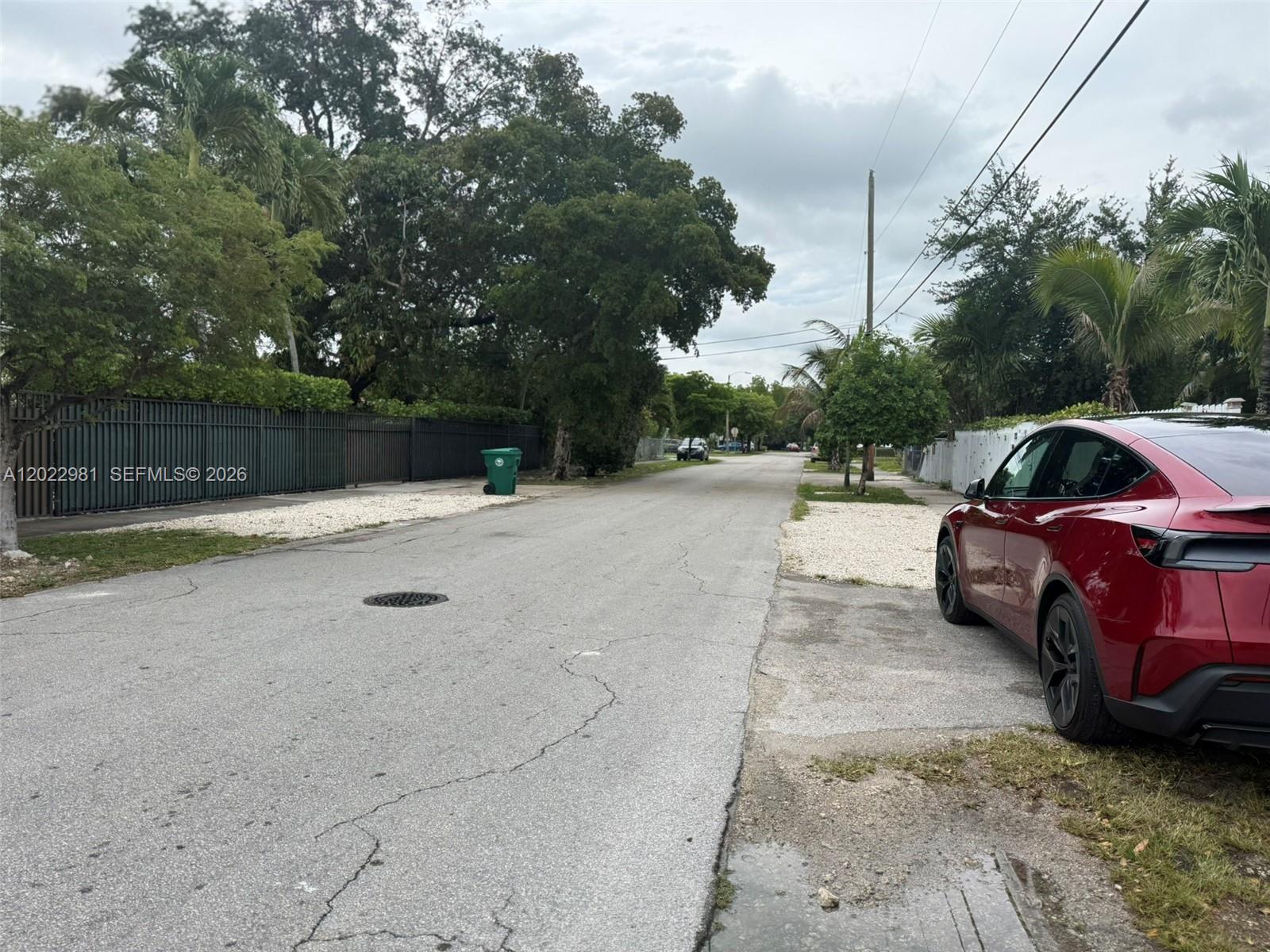 A red car is parked on the side of a residential street with trees — 5940 SW 2nd St, Miami FL 33144, MIAMI, FL