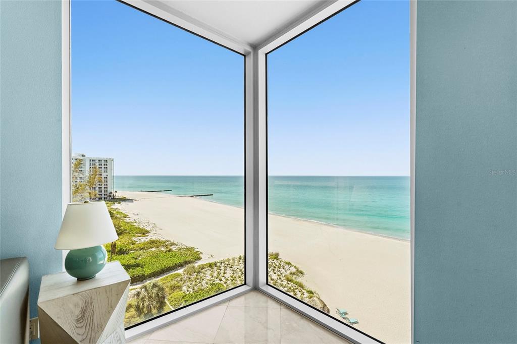 A room with a corner window overlooking a sandy beach and the ocean — 2425 GULF OF MEXICO DRIVE UNIT 8C, LONGBOAT KEY, FL