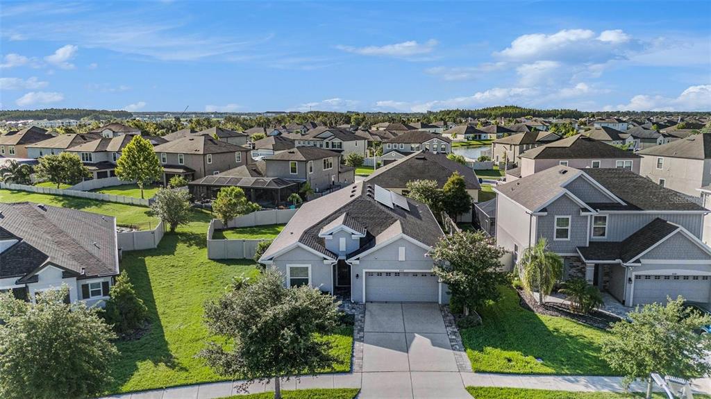 An aerial view shows a suburban neighborhood with single-family homes and manicured green lawns — 8052 OLIVE BROOK DRIVE, WESLEY CHAPEL, FL
