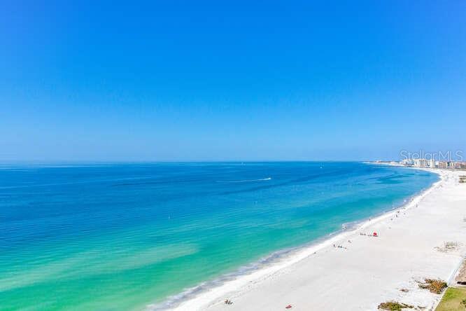 An aerial view of a white sand beach along a blue ocean under a clear sky — 1520 GULF BOULEVARD UNIT 1602, CLEARWATER BEACH, FL