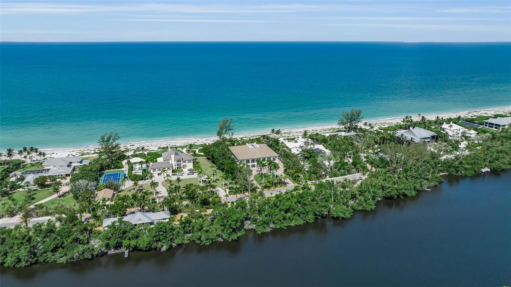 An aerial view shows luxury homes situated on a narrow strip between the ocean and bay — 8132 SANDERLING ROAD, SARASOTA, FL