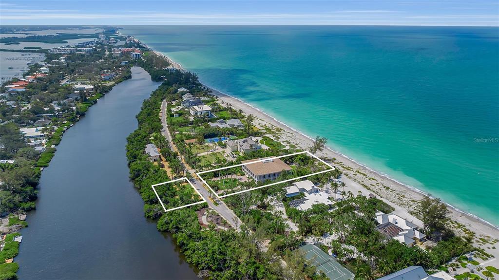 An aerial view shows a beachfront property with a large house and a vacant lot — 8132 SANDERLING ROAD, SARASOTA, FL