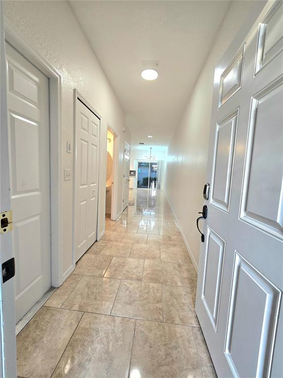 A tiled entryway leads down a long hallway toward a bright, open living area — 13241 OPAL COURT, LARGO, FL