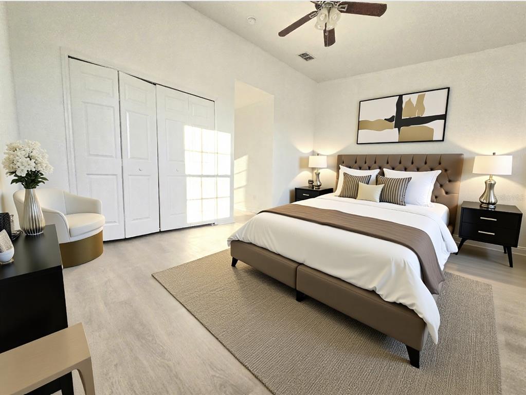 A bedroom features a tufted headboard, white bedding, a neutral area rug, and white closets — 13241 OPAL COURT, LARGO, FL