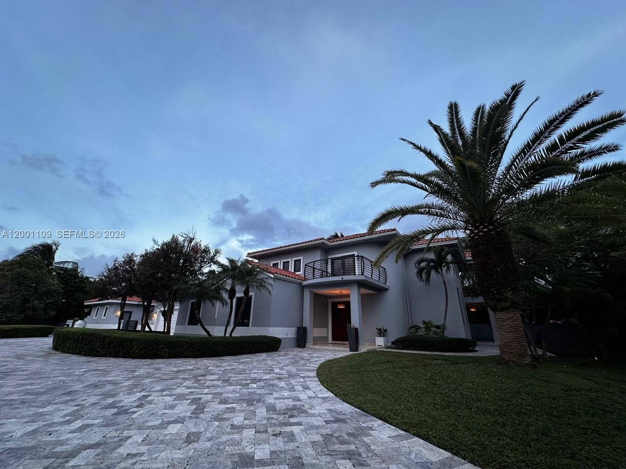 A two-story gray house features a tiled driveway, a balcony, and a large palm tree — 223 NW 129th Ave # 0, Miami FL 33182, MIAMI, FL