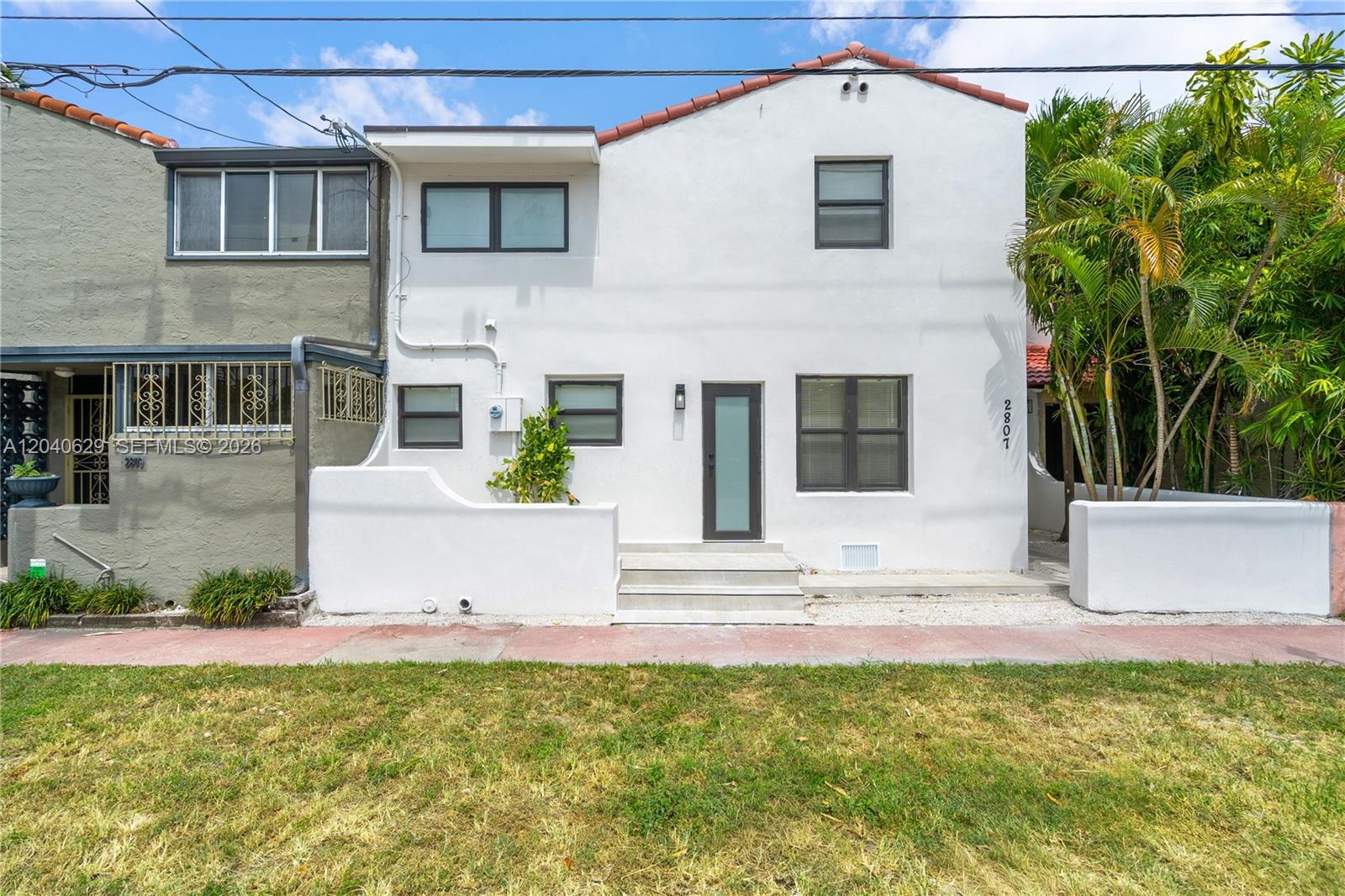 The exterior of a two-story white stucco house with a tiled roof and front steps — 337 W 28th St, Miami Beach FL 33140, MIAMI BEACH, FL