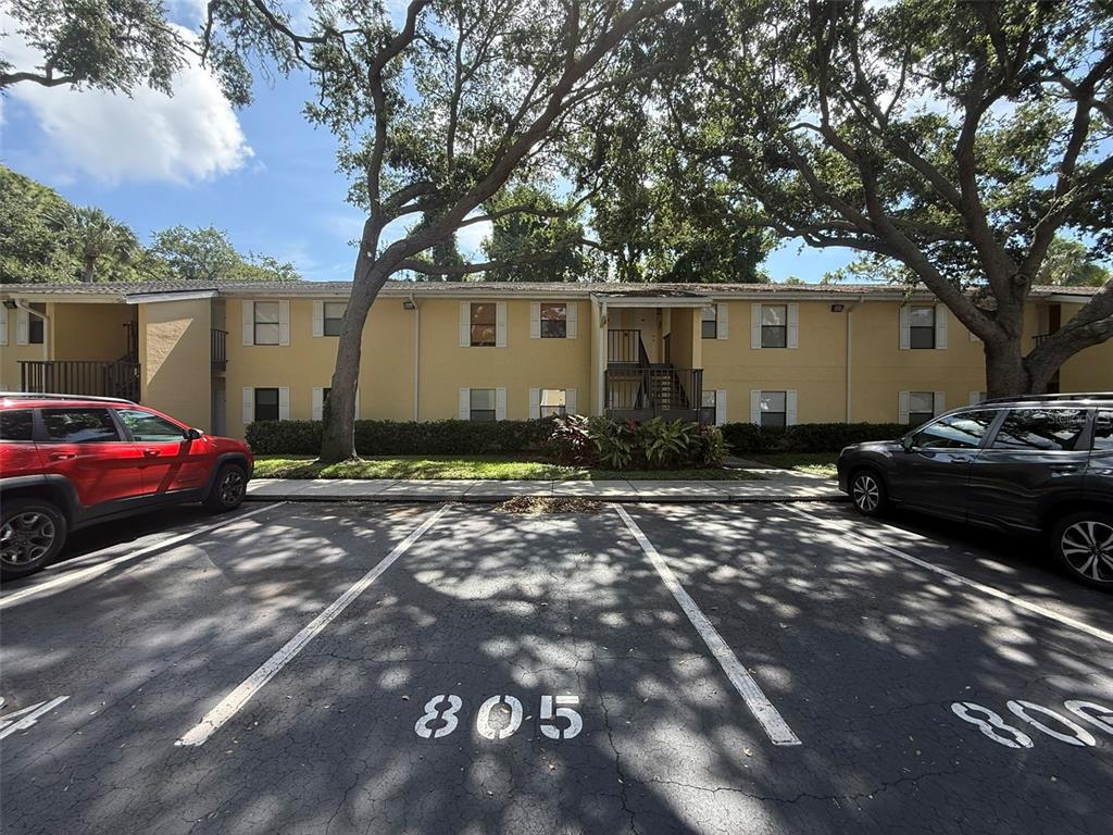 A two-story apartment building exterior with a parking lot in the foreground — 3001 58TH AVENUE S UNIT 805, ST PETERSBURG, FL
