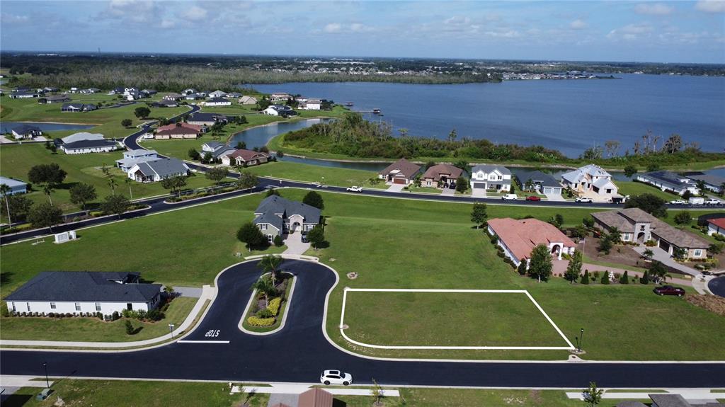 An aerial view shows a vacant residential lot outlined in white within a suburban neighborhood — 587 LOBLOLLY PLACE, AUBURNDALE, FL