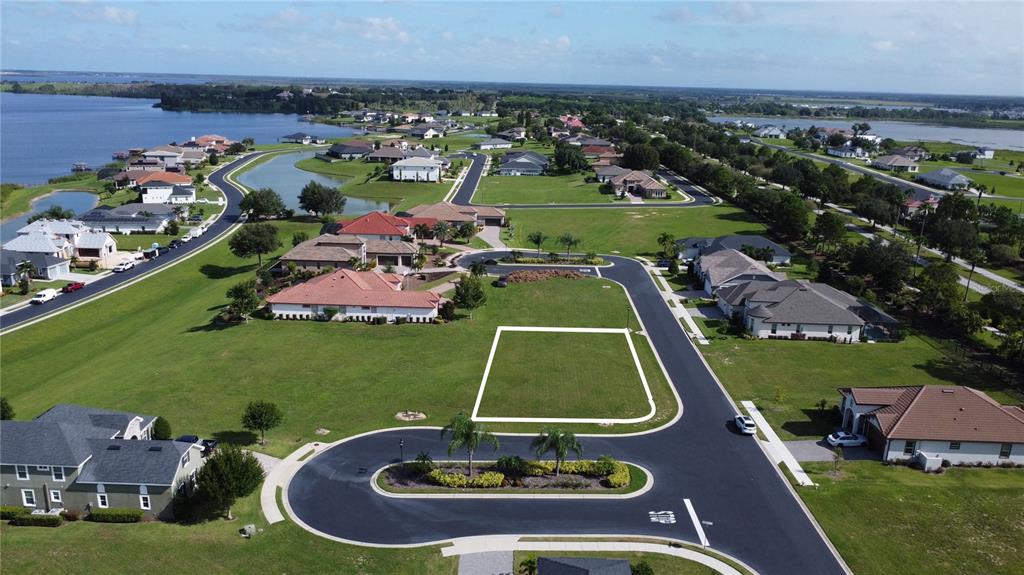 An aerial view shows a vacant residential lot outlined in white within a suburban neighborhood — 587 LOBLOLLY PLACE, AUBURNDALE, FL