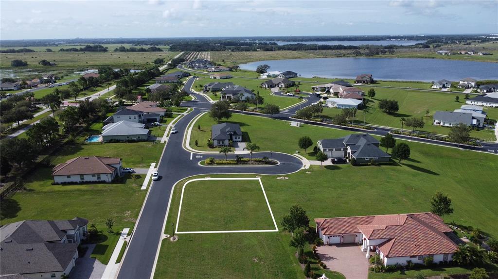 An aerial view shows a vacant residential lot outlined in white within a suburban neighborhood — 587 LOBLOLLY PLACE, AUBURNDALE, FL