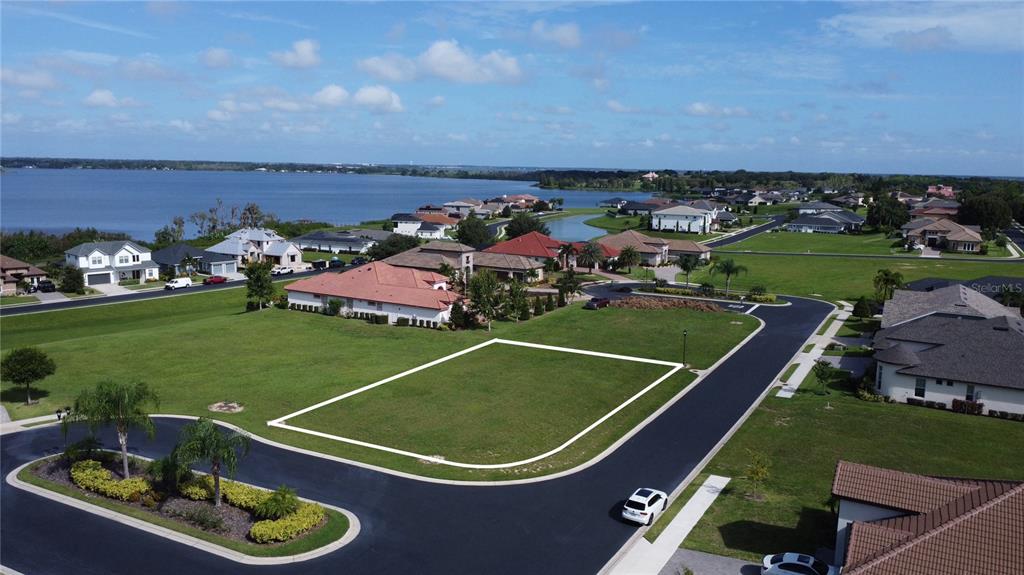 An aerial view shows a vacant residential lot outlined in white within a suburban neighborhood — 587 LOBLOLLY PLACE, AUBURNDALE, FL