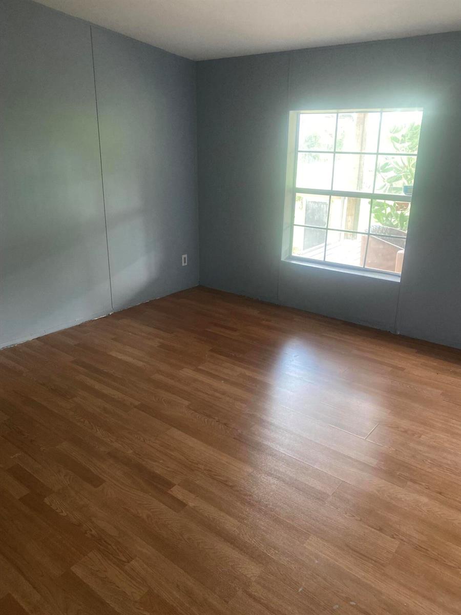 An empty bedroom features gray walls, wood-look laminate flooring, and a single window — 170 S Lindero Street, Clewiston FL 33440, CLEWISTON, FL