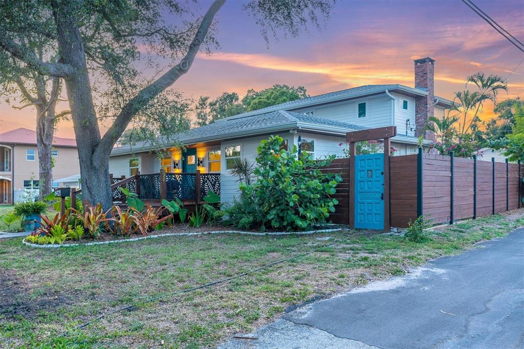 A two-story house with a wooden fence, a teal gate, and a front deck — 6921 MANGO AVENUE S, ST PETERSBURG, FL