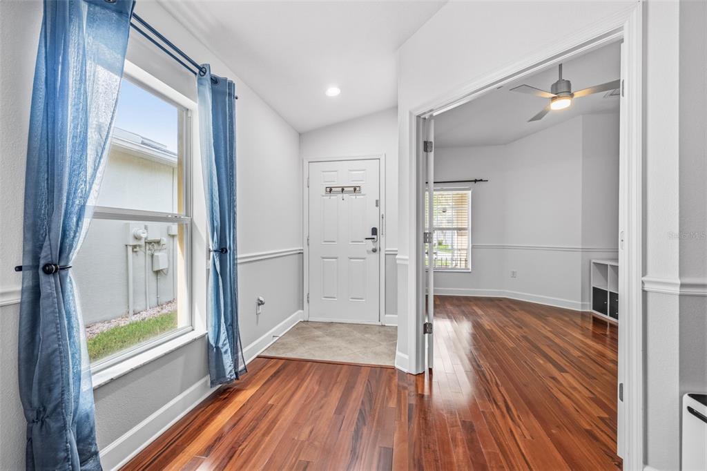 An entryway with hardwood floors, a tiled foyer, a white front door, and French doors — 7861 TUSCANY WOODS DRIVE, TAMPA, FL