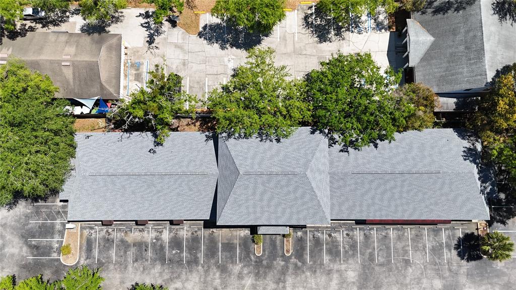 An aerial view shows a commercial building with a gray shingled roof and parking lots — 1400 W OAK STREET UNIT F, KISSIMMEE, FL