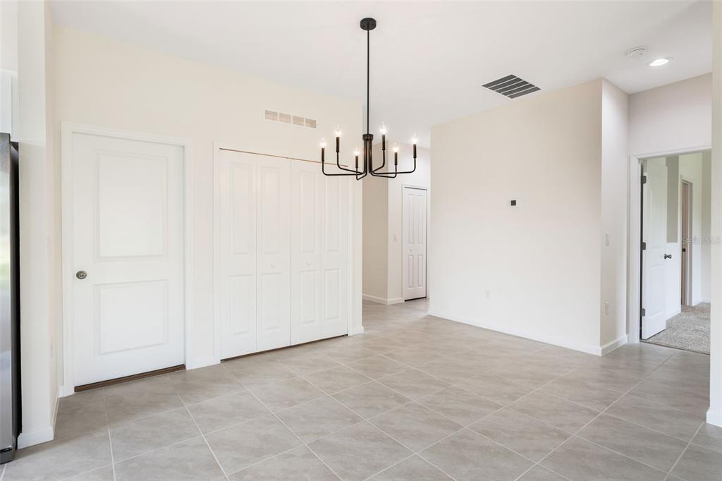 A dining area features light tile flooring, a black chandelier, and several white interior doors — 3788 WATERCLIFF CIRCLE, GRAND ISLAND, FL
