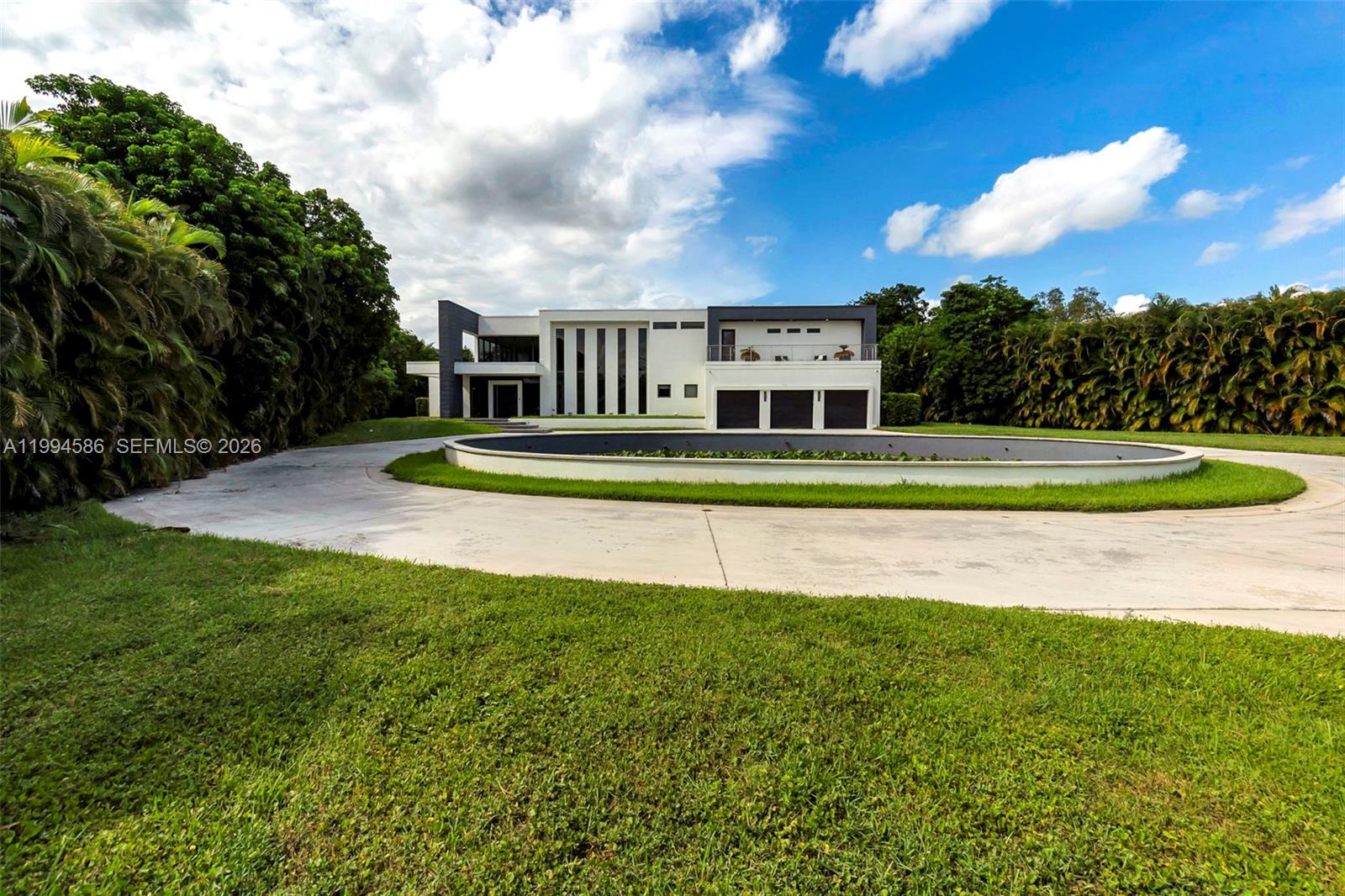 A modern two-story house features a circular driveway and a large reflecting pool — 13441 Mustang Trl, Southwest Ranches FL 33330, SOUTHWEST RANCHES, FL