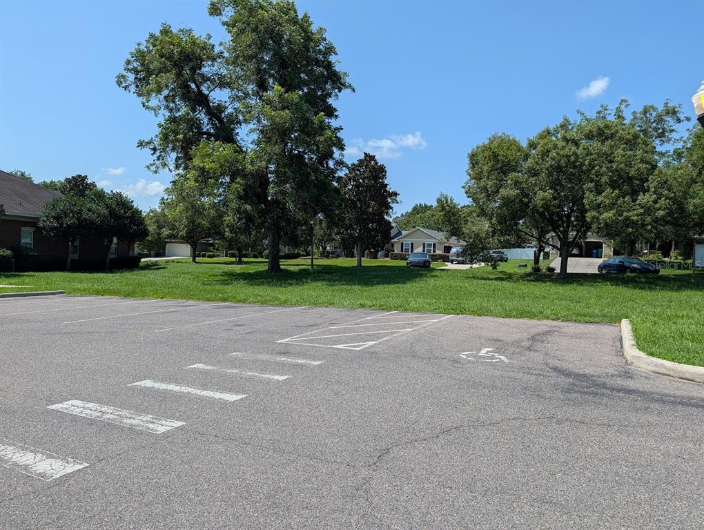 A paved parking lot with a handicap space sits in front of a grassy area — Lot 00 NW 151ST BOULEVARD, ALACHUA, FL