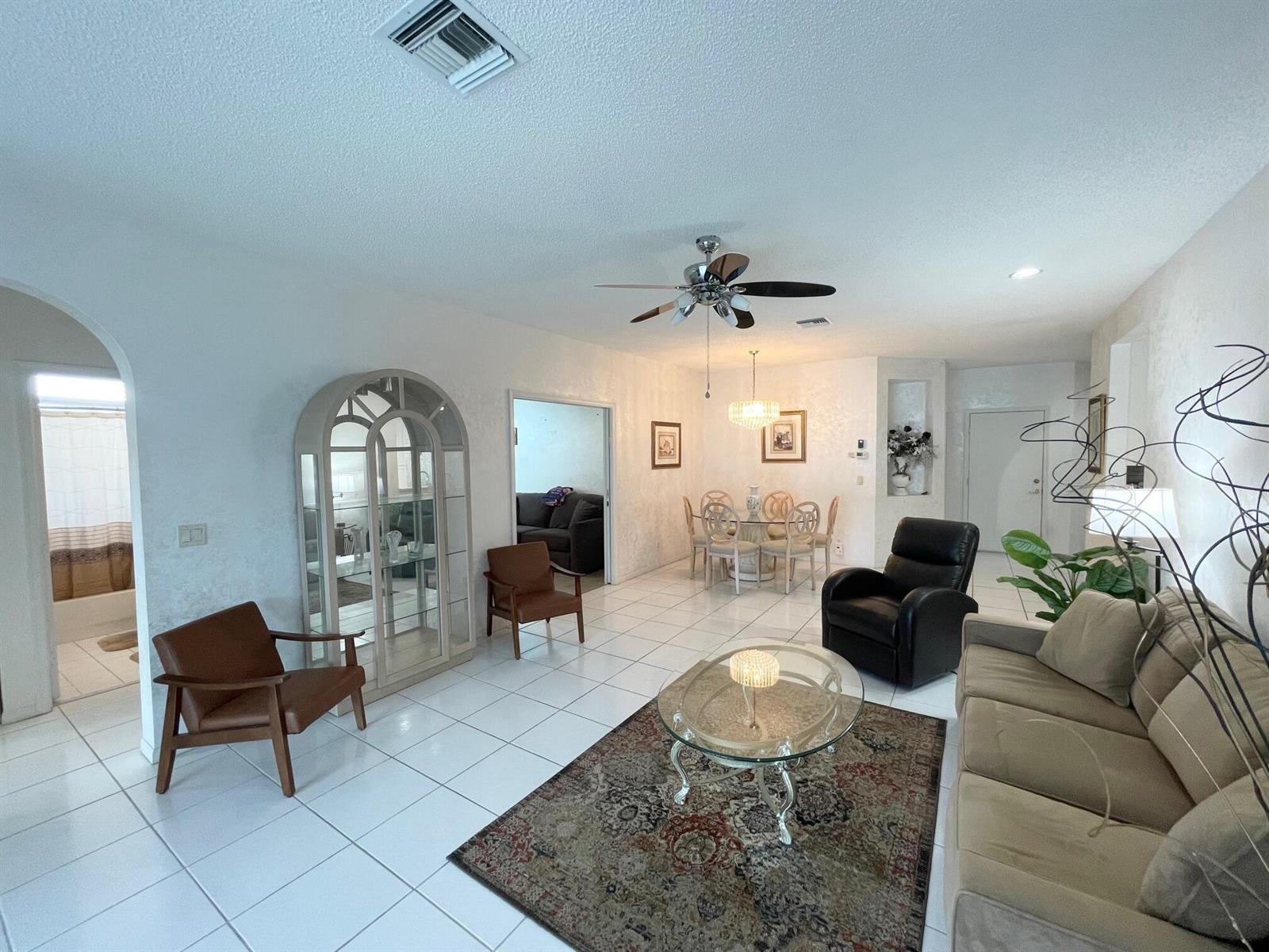 A living room with white tile floors, a glass coffee table, and a dining area — 7941 Laina Lane # 2, Boynton Beach FL 33437, BOYNTON BEACH, FL