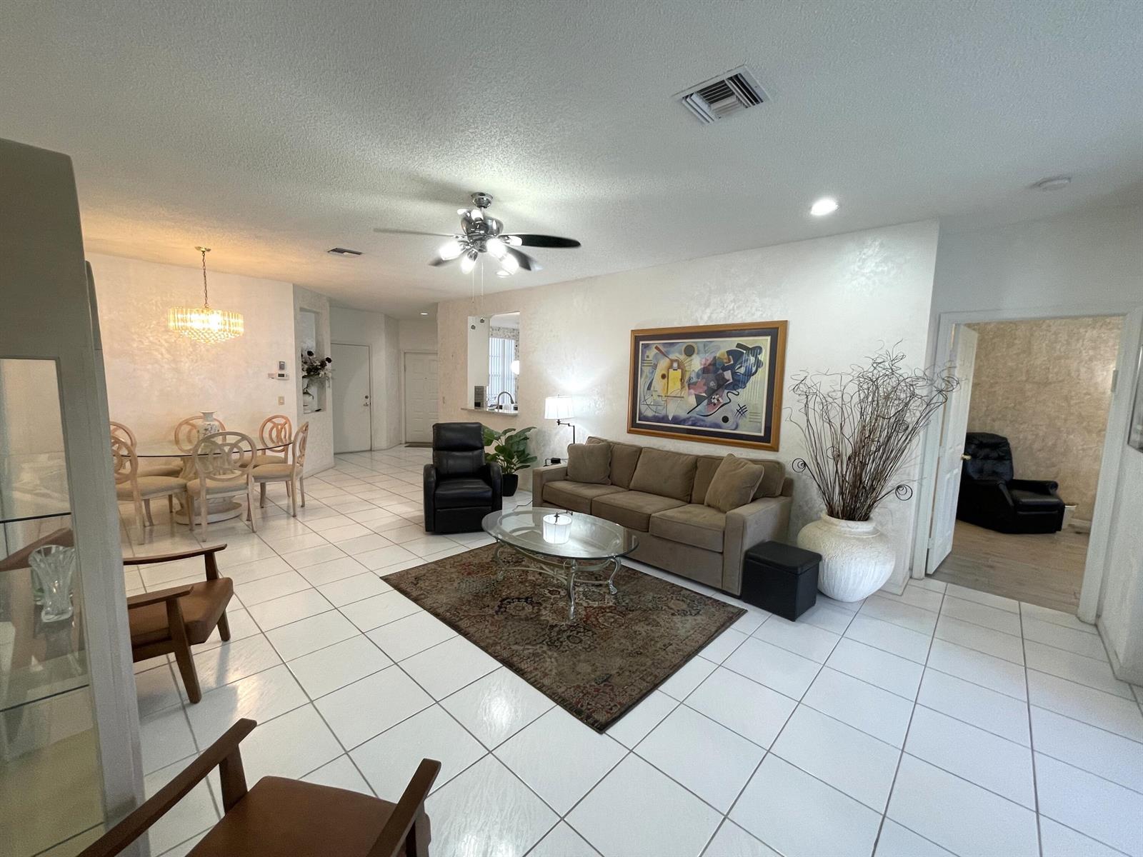 A living room with white tile floors, a brown sofa, and a dining area — 7941 Laina Lane # 2, Boynton Beach FL 33437, BOYNTON BEACH, FL