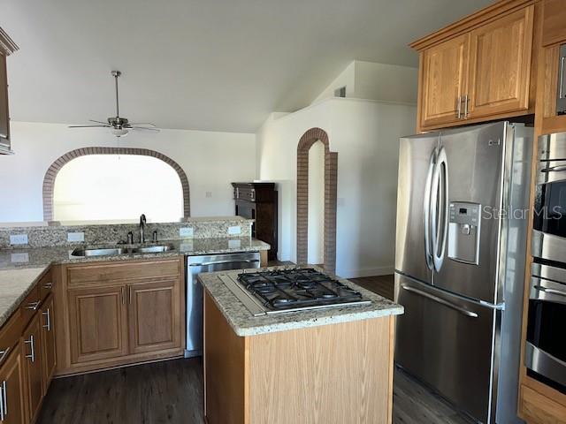 A kitchen features oak cabinets, granite countertops, a center island cooktop, and stainless steel appliances — 233 VIA DEL SOL DRIVE, DAVENPORT, FL