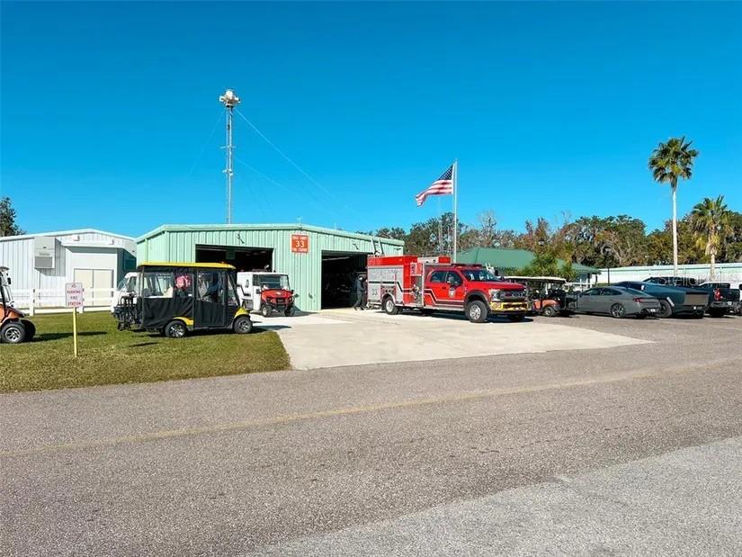 A fire station building features a red fire truck, a golf cart, and an American flag — 29129 JOHNSTON ROAD UNIT 2510, DADE CITY, FL
