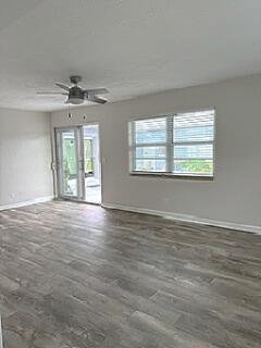 An empty room features light gray wood-look flooring, a ceiling fan, and a sliding glass door — 112 Lake Avenue # 12, FL 33460, FL
