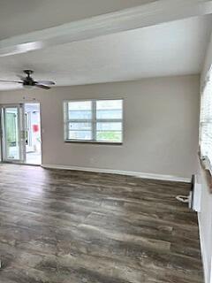 A living room with wood-look flooring, a ceiling fan, and a sliding glass door — 112 Lake Avenue # 12, FL 33460, FL