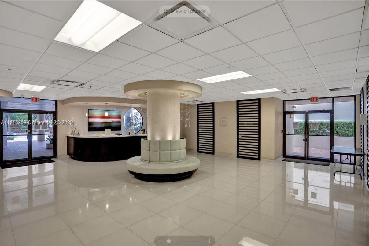 A lobby features a central circular seating area, a reception desk, and tiled flooring — 1621 Collins Ave # 505, Miami Beach FL 33139, MIAMI BEACH, FL
