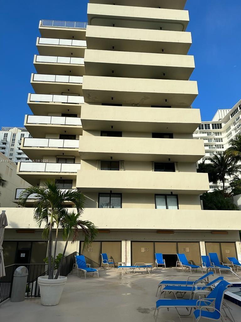 A multi-story apartment building exterior with balconies overlooking a pool deck with lounge chairs — 1621 Collins Ave # 505, Miami Beach FL 33139, MIAMI BEACH, FL