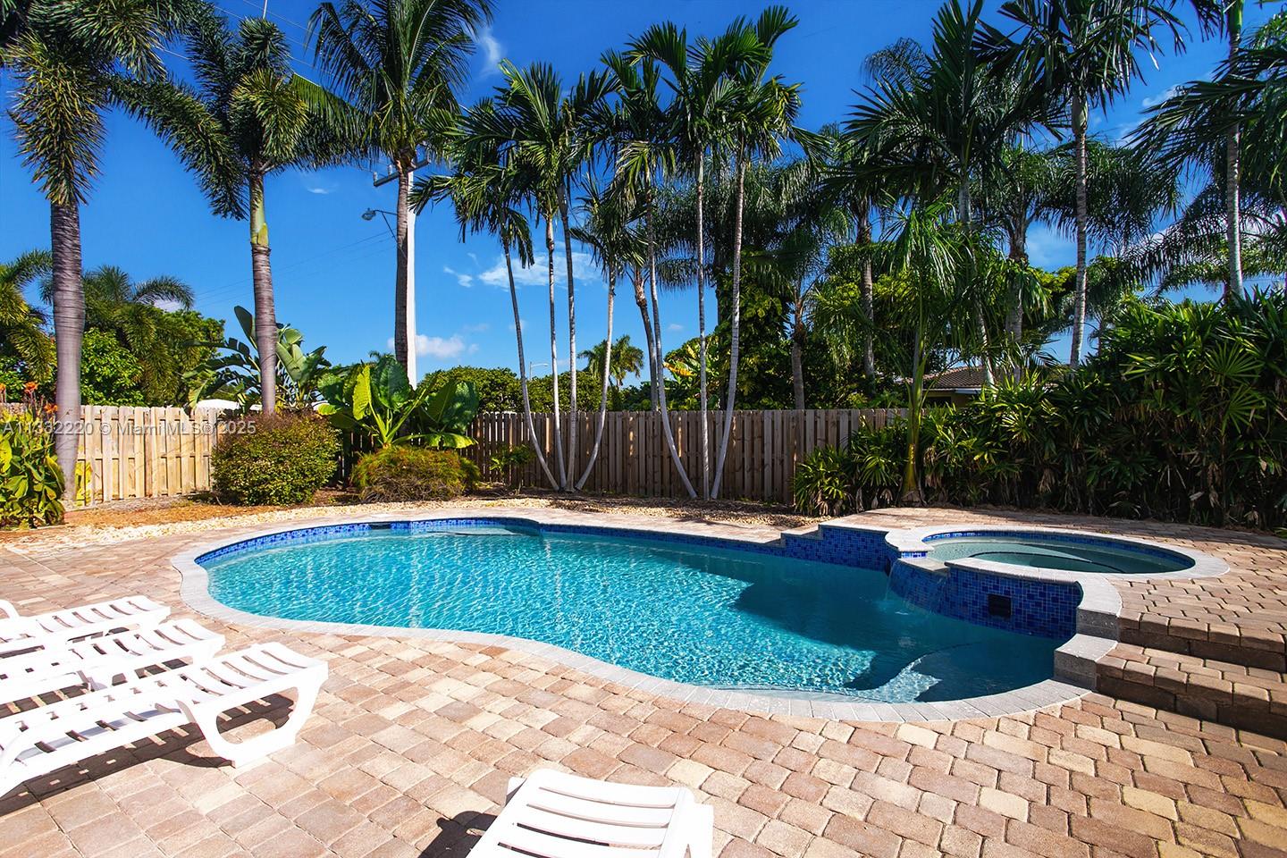 A backyard features a swimming pool with an attached spa and a brick paver patio — 333 SE 3rd Ave, Dania Beach FL 33004, DANIA BEACH, FL