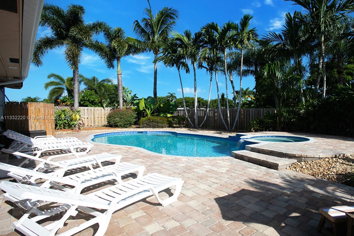 A backyard features a swimming pool, a raised spa, and several white lounge chairs — 333 SE 3rd Ave, Dania Beach FL 33004, DANIA BEACH, FL