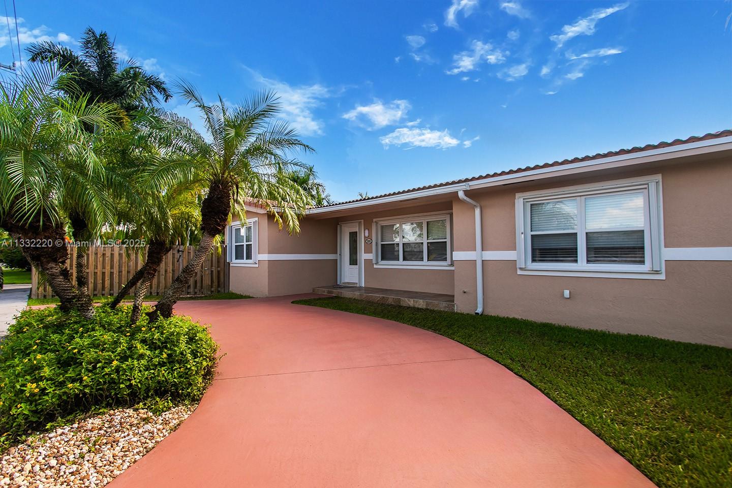 A single-story house with a red driveway, tan exterior, and palm trees in the front yard — 333 SE 3rd Ave, Dania Beach FL 33004, DANIA BEACH, FL