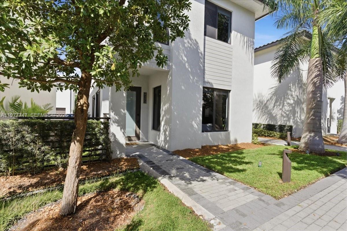 A modern two-story white house features a paved walkway leading to the front entrance — 4395 NW 80th Ct, Doral FL 33166, DORAL, FL