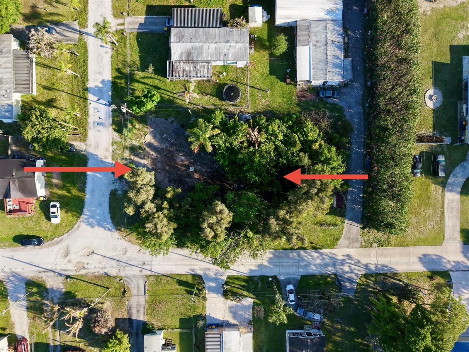 An aerial view shows a vacant, partially wooded residential lot between two paved roads — 0 Unassigned, Stuart FL 34997, STUART, FL